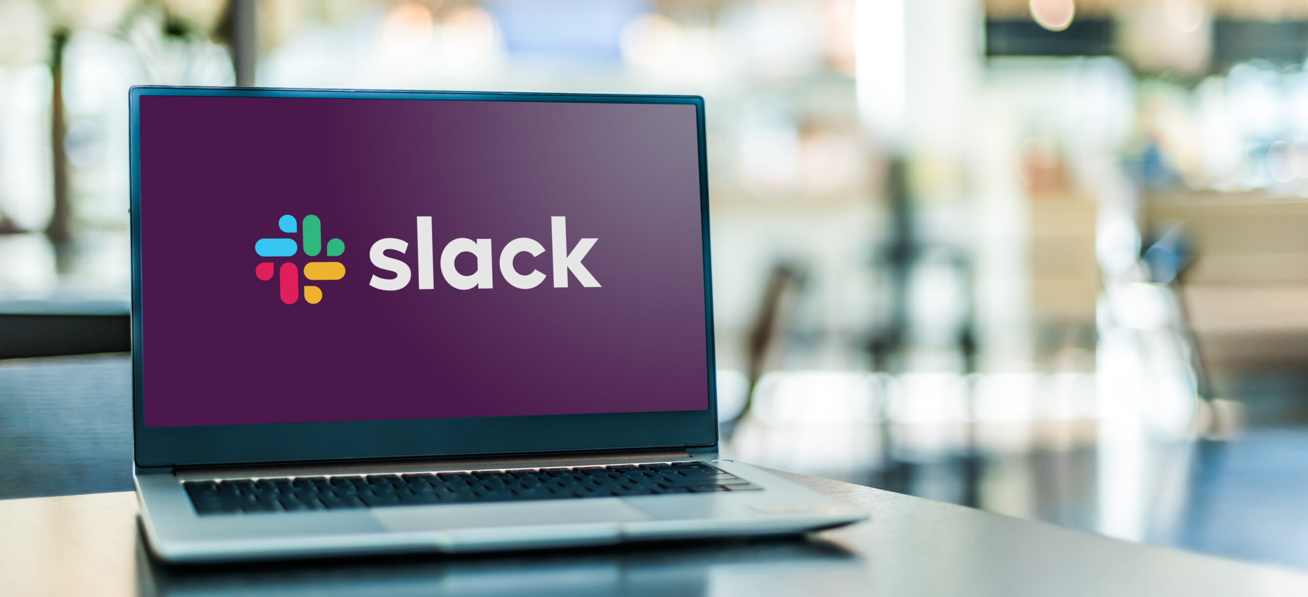 Photograph of laptop displaying logo of Slack